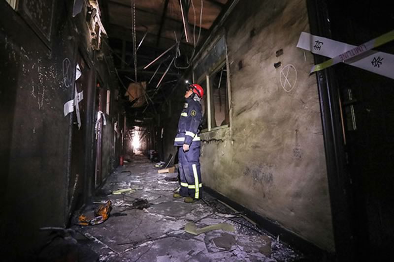 Firefighters inspect the burnt out Gathering Good Fortune Building in Daxing